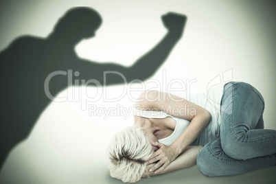 Composite image of sad blonde woman lying on the floor