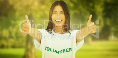 Composite image of woman wearing volunteer tshirt giving thumbs