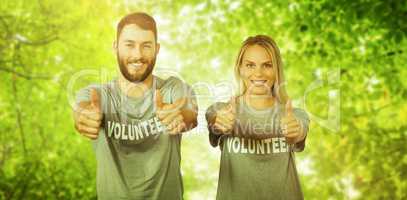 Composite image of smiling volunteers giving thumbs up