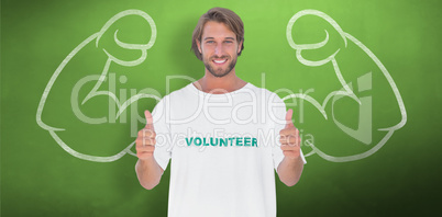 Composite image of happy man wearing volunteer tshirt giving thu