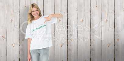 Composite image of portrait of a happy female volunteer pointing
