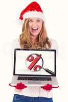 Composite image of festive blonde showing a laptop