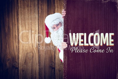 Composite image of smiling santa claus presenting sign
