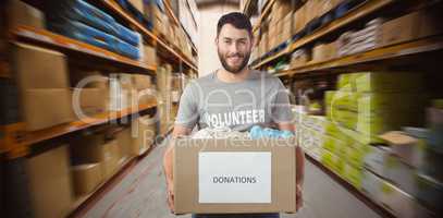 Composite image of portrait of man holding clothes donation box