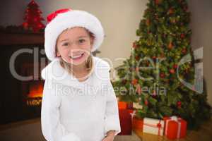 Composite image of cute little girl wearing santa hat