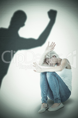 Composite image of scared woman protecting herself