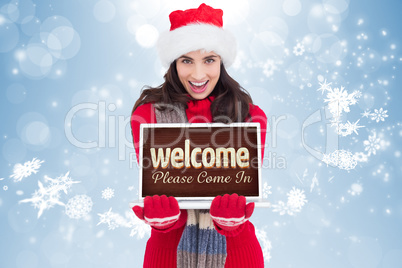 Composite image of festive brunette showing a laptop
