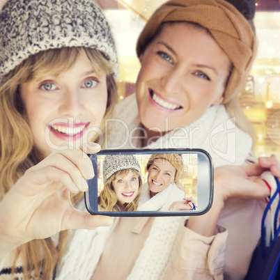 Composite image of hand holding smartphone showing