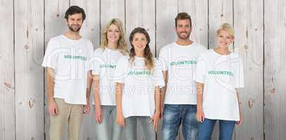 Composite image of group portrait of happy volunteers
