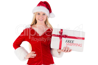 Composite image of festive blonde holding a gift