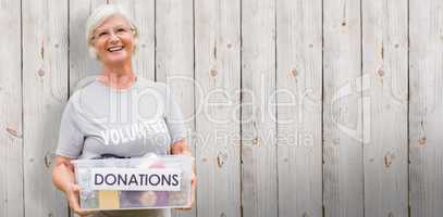 Composite image of happy grandmother holding donation box