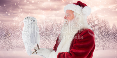 Composite image of father christmas holds an owl