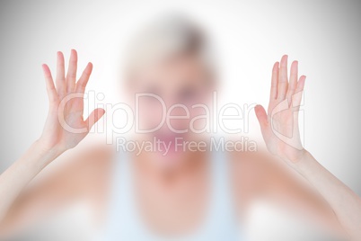 Composite image of angry blonde screaming with hands up