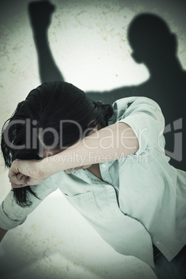 Composite image of sad woman sitting on the floor and hiding her