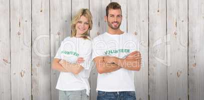Composite image of portrait of two happy volunteers with hands c