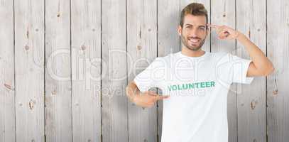 Composite image of portrait of a happy male volunteer pointing t