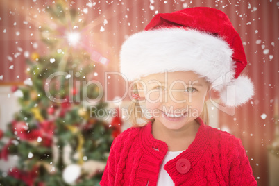 Composite image of cute little girl wearing santa hat