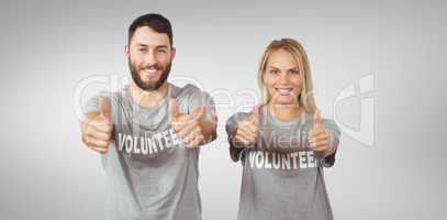 Composite image of smiling volunteers giving thumbs up