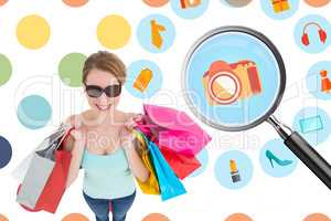 Composite image of woman holding shopping bags wearing sunglasse
