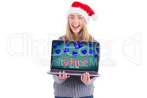 Composite image of festive blonde holding a laptop