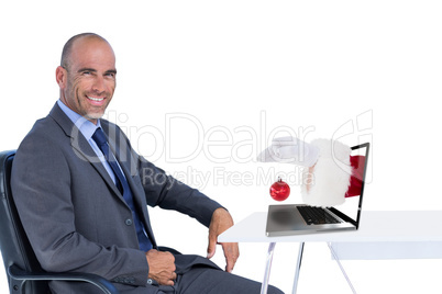 Composite image of santa claus holding red bauble