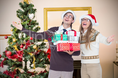 Composite image of smiling man and woman wearing santa hats and