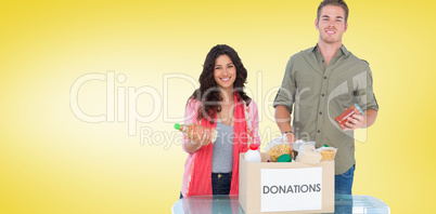 Composite image of smiling volunteers taking out food from donat