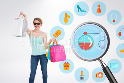 Composite image of woman holding shopping bags wearing sunglasse