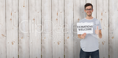 Composite image of man holding a donation welcome note while ges