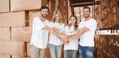 Composite image of group portrait of happy volunteers with hands