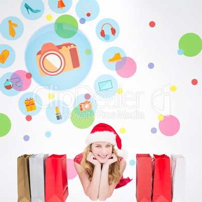 Composite image of smiling woman lying between shopping bags