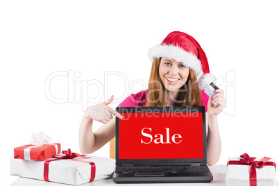 Composite image of festive redhead shopping online with laptop