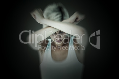 Composite image of upset woman holding her arms in front of her