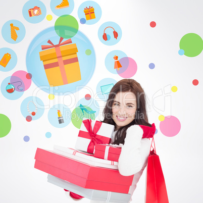 Composite image of joyful brunette holding christmas gifts and s