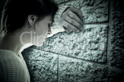 Composite image of sad pretty brunette leaning against wall