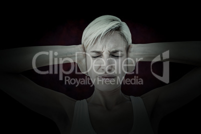 Composite image of upset woman covering her ears