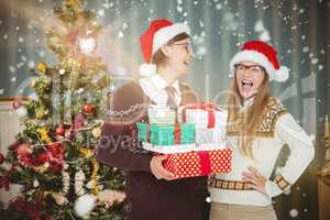 Composite image of geeky hipster couple holding presents
