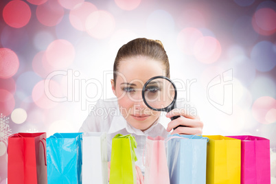 Composite image of businesswoman typing and looking through magn