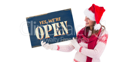 Composite image of festive brunette holding a poster
