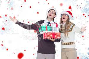 Composite image of smiling man and woman wearing santa hats and