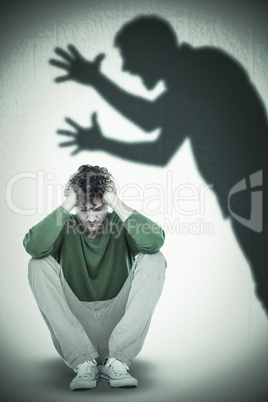 Composite image of sad casual man sitting with hand on head