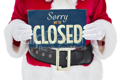 Composite image of mid section of santa claus holding page