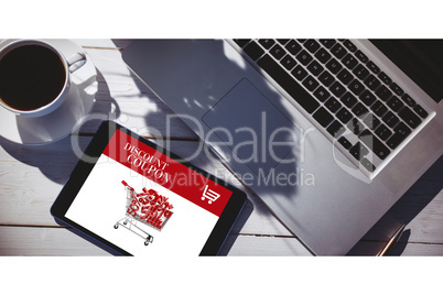 Composite image of tablet on desk with laptop and coffee Composite image of tablet on desk with laptop and coffee