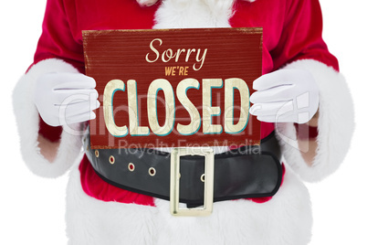 Composite image of mid section of santa claus holding page