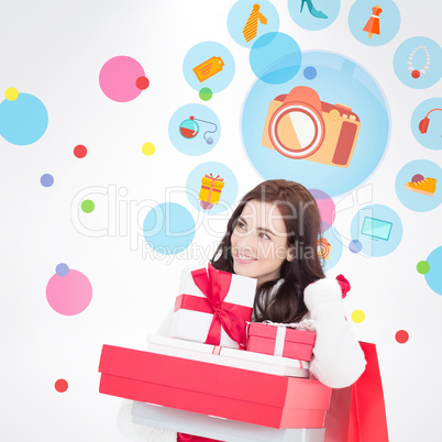 Composite image of happy brunette holding christmas gifts and sh