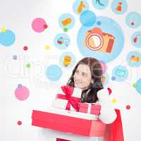 Composite image of happy brunette holding christmas gifts and sh