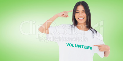 Composite image of smiling woman pointing to her volunteer tshir