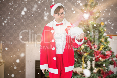 Composite image of geeky hipster in santa costume looking at bea