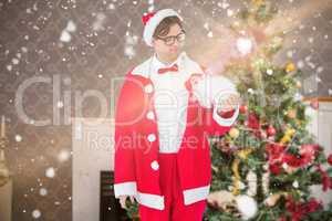 Composite image of geeky hipster in santa costume looking at bea