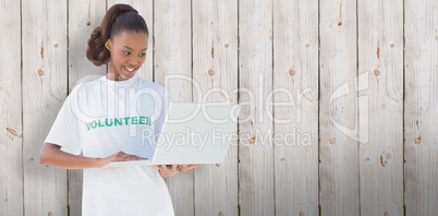 Composite image of happy volunteer using laptop